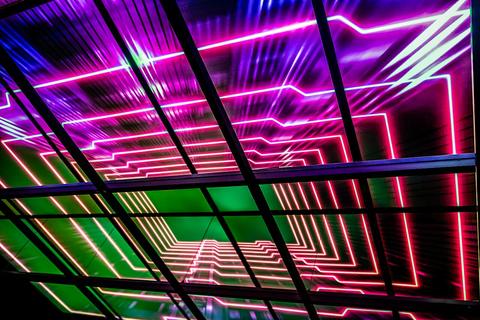 Bright neon pink and green laser light grid glowing in a dark arcade-style space, Brick Battle
