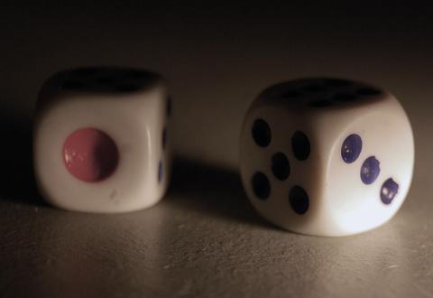 Two white dice with coloured pips resting on a table in dramatic low light, Five Dice