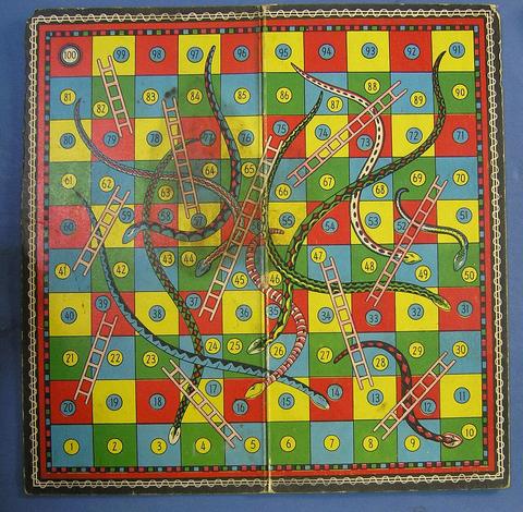 Vintage colourful snakes and ladders board with numbered squares, snakes and ladders game