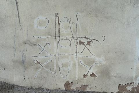 Tic-Tac-Toe free online multiplayer game — tic-tac-toe grid scratched on a wall